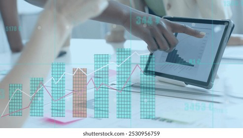 Image of financial data processing over diverse businesswomen working in office. Global business, finance, computing and data processing concept digitally generated image.