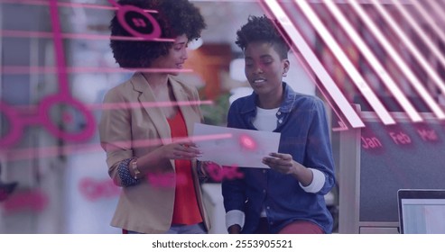 Image of financial data processing over diverse colleagues discussing work in office. Global business, finances and digital interface concept digitally generated image.