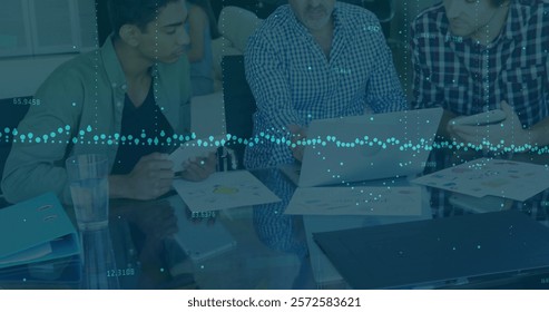 Image of financial data processing over diverse business people in office. Global finance, business, connections, computing and data processing concept digitally generated image.