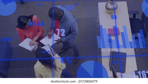 Image of financial data processing over diverse colleagues discussing work in office. Global business, finances, computing and digital interface concept digitally generated image.