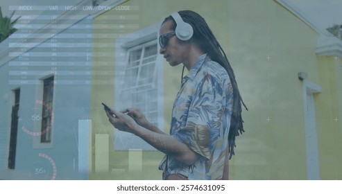 Image of financial data processing over biracial man using smartphone. Global business, finances, computing and data processing concept digitally generated image.