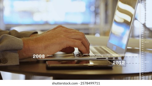 Image of financial data processing over caucasian businessman using laptop in office. Global finance, business, connections, computing and data processing concept digitally generated image.