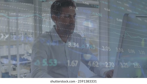 Image of financial data processing over caucasian businessman using computer in office. Global finance, business, connections, computing and data processing concept digitally generated image.