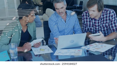 Image of financial data processing over diverse colleagues discussing work in office. Global business, finances, computing and digital interface concept digitally generated image.