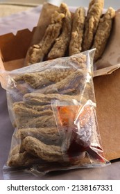 Image Of Fish Cakes In A Packet With Hot Chilli Sauce With Blurry Unpacked Fish Cake In A Box As Background. This Famous Local Food In Malaysia Known As Keropok Lekor Made From Fish And Flour. 