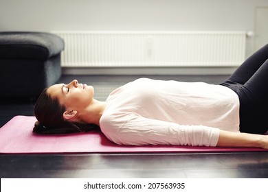 Image Of Fit Young Woman Relaxing On Yoga Mat. Female Lying On Floor - Savasana