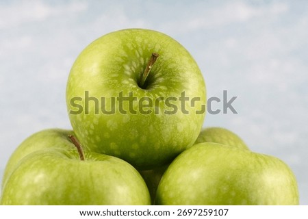Image of five granny smith apples.