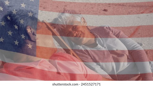 Image of flag of united states of america over senior biracial couple in deckchairs on beach. American patriotism, diversity and tradition concept digitally generated image. - Powered by Shutterstock