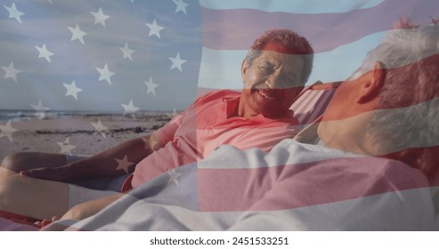 Image of flag of united states of america over senior biracial couple in deckchairs on beach. American patriotism, diversity and tradition concept digitally generated image. - Powered by Shutterstock