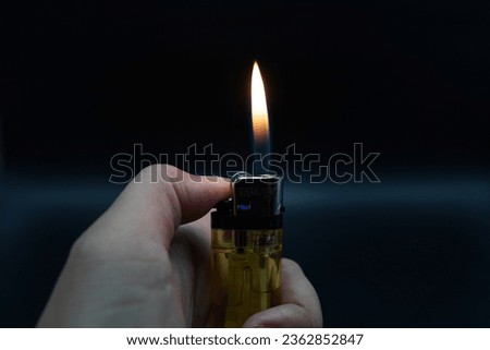 Image of flames on a dark background, orange flames created by a lighter are displayed.