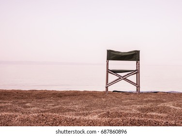 Image of a folding chair on an empty beach sand
