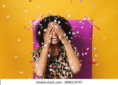 Image of funny african american woman smiling while covering her eyes isolated over multicolored background - Shutterstock ID 1808170747