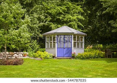 Image of gazebo house in a lush green back garden. 