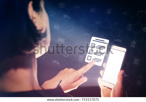 Image of a girl with a smartphone in hands. She\
presses on the  questionnaire icon. Concept of online testing,\
questionnaires, voting.
