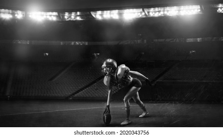 Image of a girl in the uniform of an American football team player preparing to play the ball at the stadium. Sports concept. Mixed media - Powered by Shutterstock