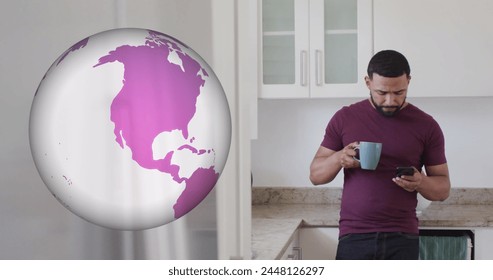 Image of globe spinning and biracial man using smartphone in kitchen. Global travel, technology, digital interface and data processing concept digitally generated image.