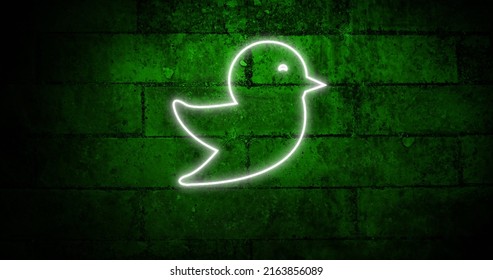 Image of glowing neon bird icon on brick wall. social media and communication concept digitally generated image. - Powered by Shutterstock