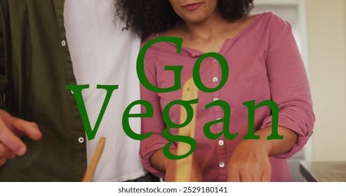 Image of go vegan text over diverse couple cooking. national vegetarian week and celebration concept digitally generated image. - Powered by Shutterstock