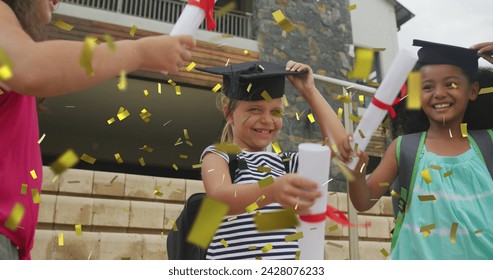 Image of gold confetti over celebrating diverse schoolgirls with mortar boards and diplomas. School, achievement, education, childhood and graduation, digitally generated image. - Powered by Shutterstock