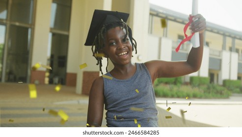 Image of gold confetti over happy african american schoolboy in mortar board holding diploma. Achievement, graduation, school, childhood, education and learning, digitally generated image. - Powered by Shutterstock