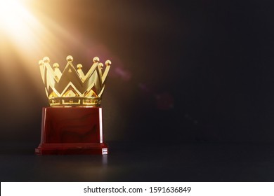 image of golden crown award over wooden table.