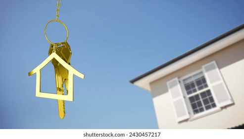 Image of golden house keys and house shaped key fob hanging over a house and blue sky 4k - Powered by Shutterstock