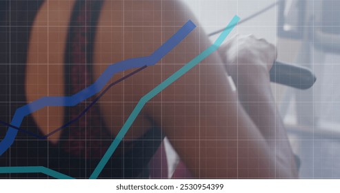 Image of graph processing data over midsection of biracial woman using rowing machine at gym. Fitness, exercise, strength, data, digital interface and technology digitally generated image. - Powered by Shutterstock