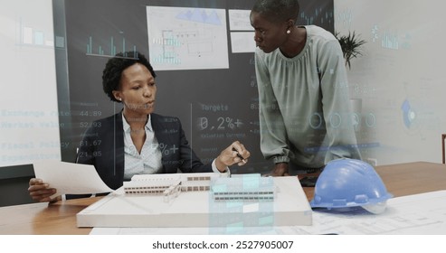 Image of graphs and changing numbers, diverse female architects discussing 3d model of building. Digital composite, multiple exposure, report, business, growth, teamwork and architecture concept. - Powered by Shutterstock