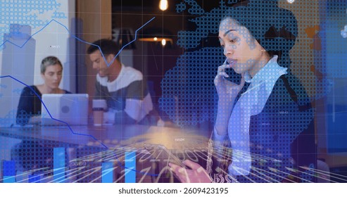 Image of graphs, data and digital interface over woman using tablet computer and talking on phone in casual office with colleagues in background. Global digital network concept digital composite.