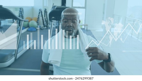 Image of graphs, loading bars, map, tired african american man wiping head with towel in gym. Digital composite, multiple exposure, report, business, progress, global and fitness concept. - Powered by Shutterstock