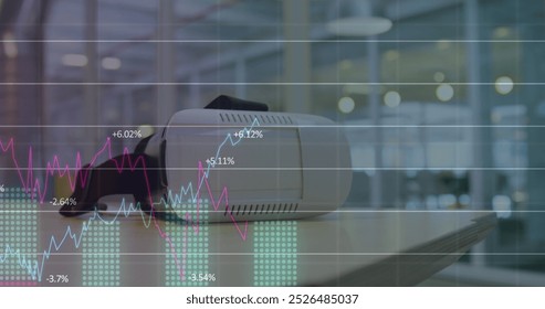 Image of graphs and numbers over vr headsets on table. Digital composite, multiple exposure, digits, growth, report, business, illuminated and technology concept.