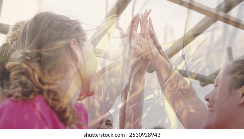 Image of grass over diverse women at obstacle course high fiving. Global sport, health, fitness and digital interface concept digitally generated image. - Powered by Shutterstock