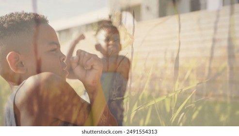 Image of grasses over happy diverse schoolboys stretching in outdoor yoga class. Health, wellbeing, school, childhood, education and learning, digitally generated image. - Powered by Shutterstock