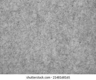 An image a gray fibrous texture. Monochrome homogeneous background with speckled felt.