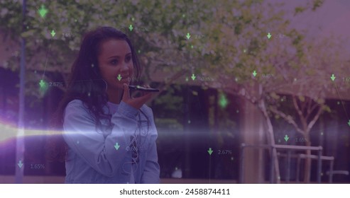 Image of green arrows and data processing over smiling biracial woman using smartphone outdoors. Global communication, business, data and digital interface concept digitally generated image. - Powered by Shutterstock