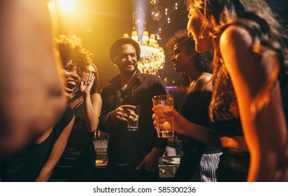 Image group of friends enjoying a party at pub. Happy young people having fun at nightclub. - Shutterstock ID 585300236