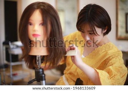 Image of a hairdresser practicing cutting hair 