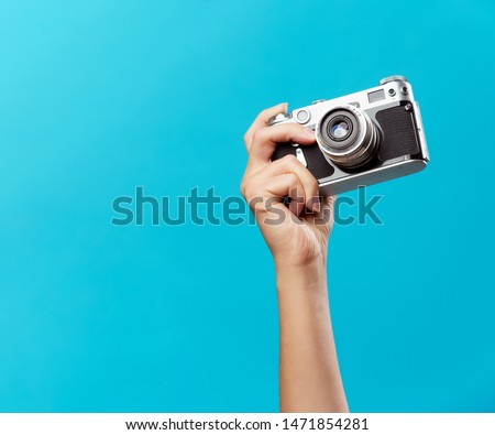 Image of hand with phone on empty blue background
