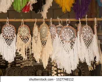 an image of a handcraft named dream Catcher. Made and hand knitted with yarn, feathers and seashells. Taken in a marketplace, 