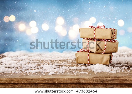 Image of handmade gift boxes over snowy wooden table

