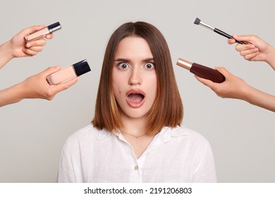 Image Of The Hands Of Beauticians Holding Their Respective Equipment For Makeup To Beautiful Shocked Woman With Open Mouth And Big Eyes, Fashionable Female Preparing For Party.