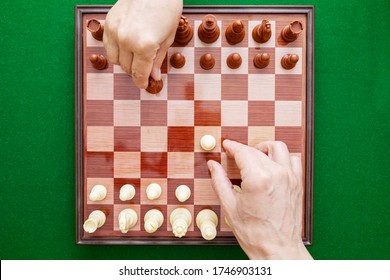 Image Of Hands Playing Chess On A Green Background. Hands Start A Chess Game. World Chess Day. International Chess Day. July 20. View From Above.