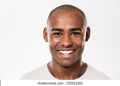 Image of handsome smiling young african man standing isolated over white background. Looking camera.