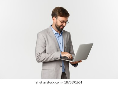 Image Of Handsome Successful Businessman Working, Standing In Grey Suit And Using Laptop, Standing Over White Background