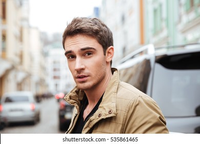 Image Of Handsome Young Man Walking On The Street And Looking At Camera.