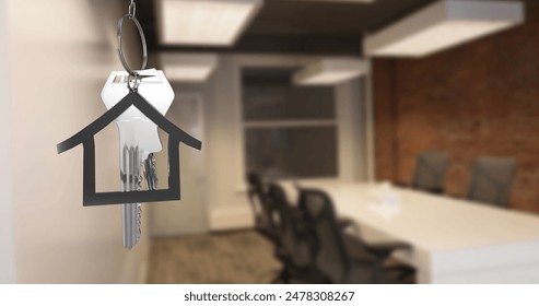 Image of hanging silver house keys against interior of a office conference room. Interior designing and real estate concept - Powered by Shutterstock