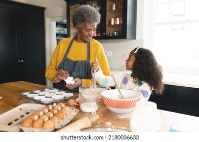 Image Of Happy African American Grandmother And Granddaughter Baking In Kitchen. Family And Spending Quality Time Together Concept.