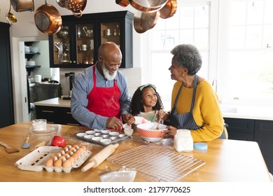 Image of happy african american grandparents and granddaughter baking in kitchen. Family and spending quality time together concept. - Powered by Shutterstock