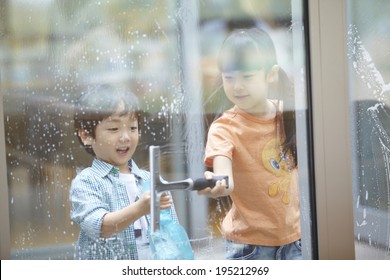 The Image Of A Happy Asian Kids Cleaning Windows