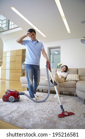 The Image Of A Happy Asian Man Vacuuming